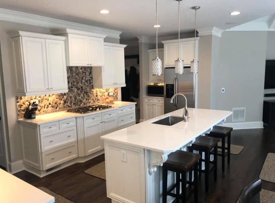 Kitchen with cabinets and island refinished in white