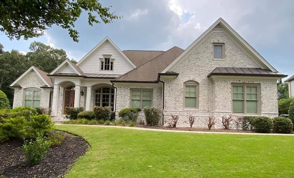 Limewashed brick home with soft white trim
