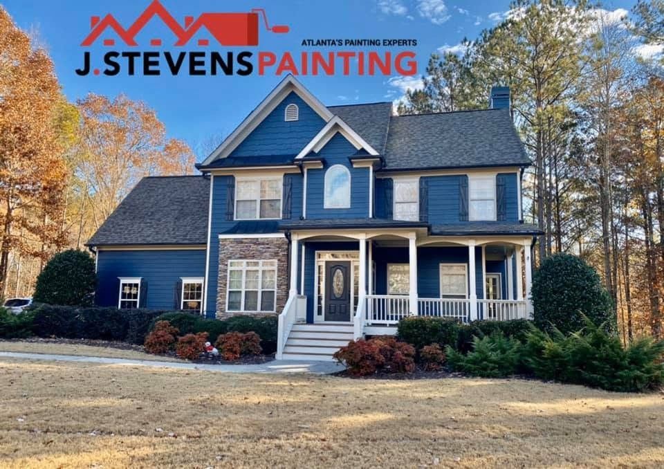 Navy two-story home with white porch and stone accent